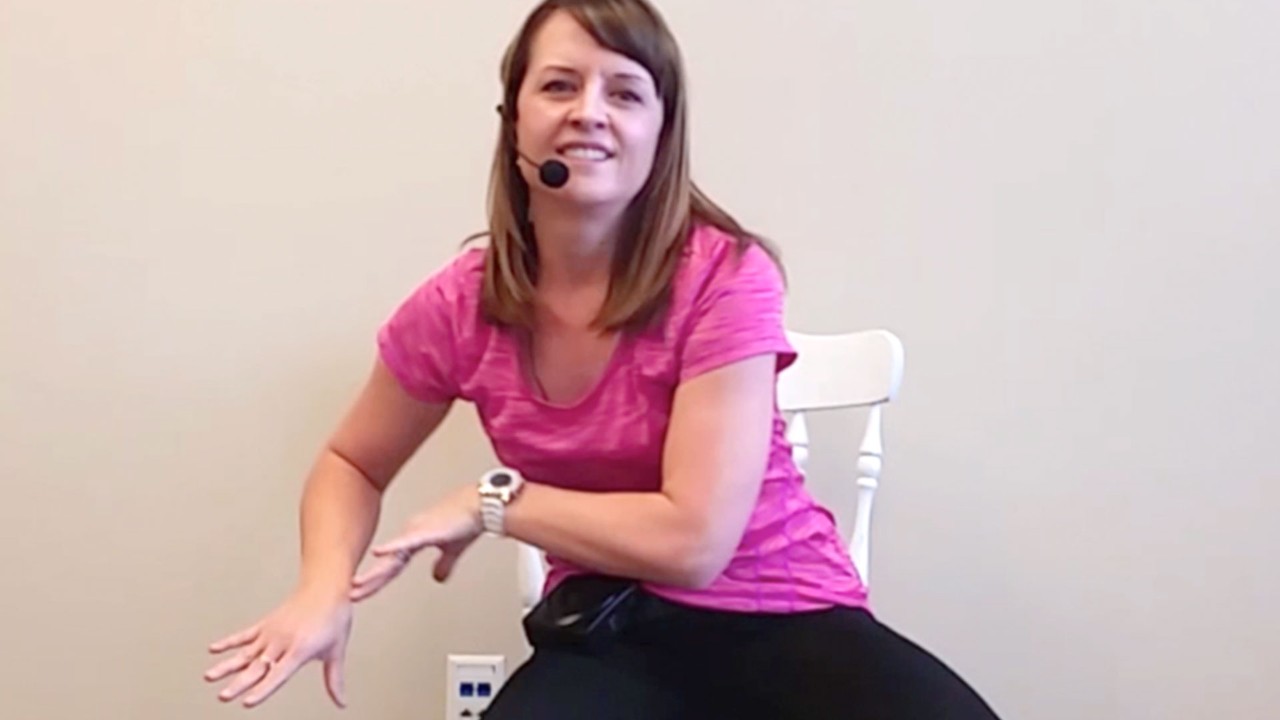 screenshot of woman demonstrating seated zumba exercise